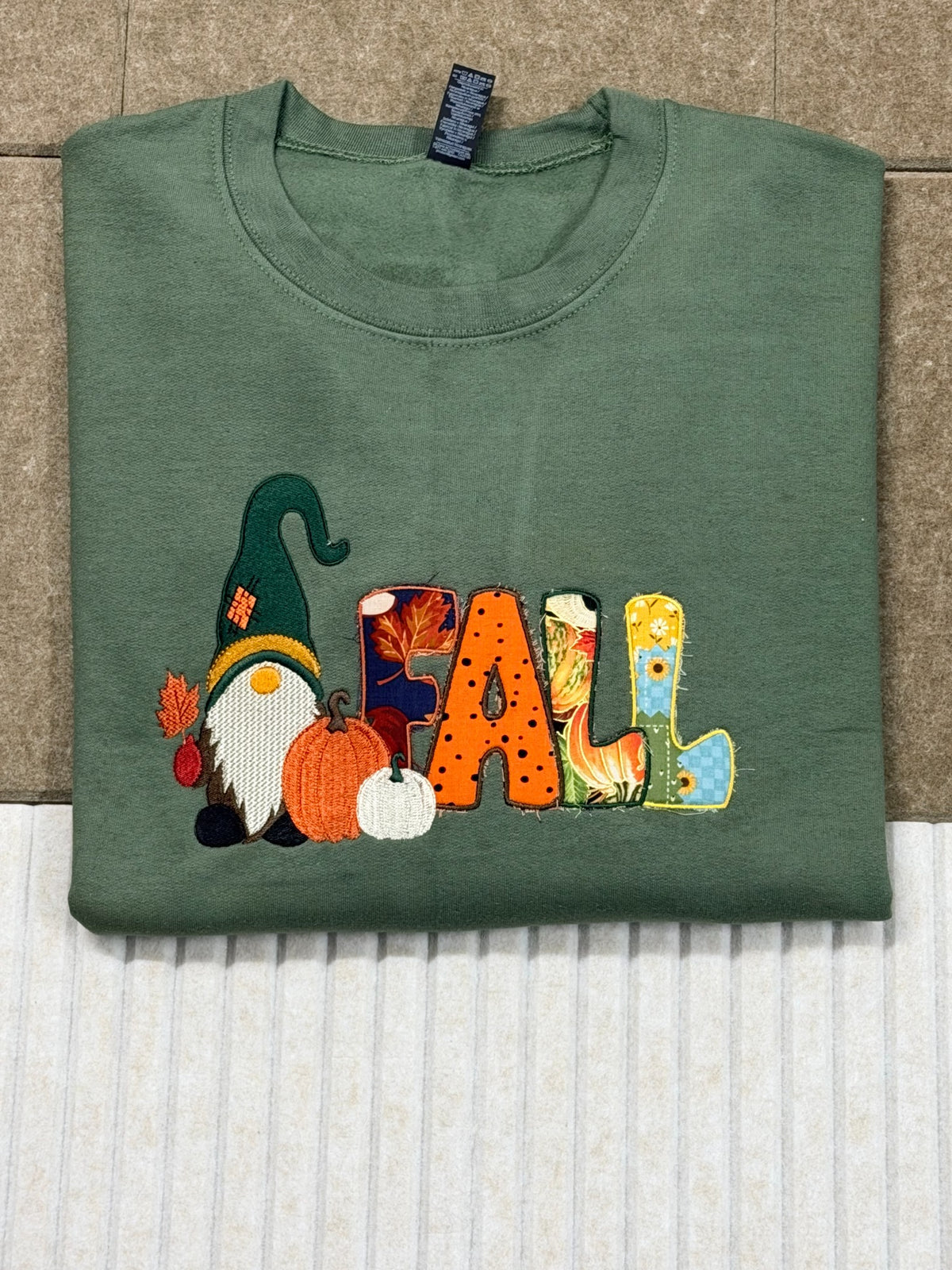 Folded green Gildan Heavy Blend Fall gnome embroidered sweatshirt